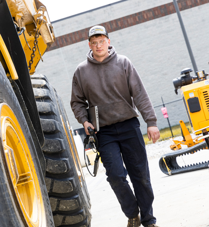 mechanic walking beside heavy machinery